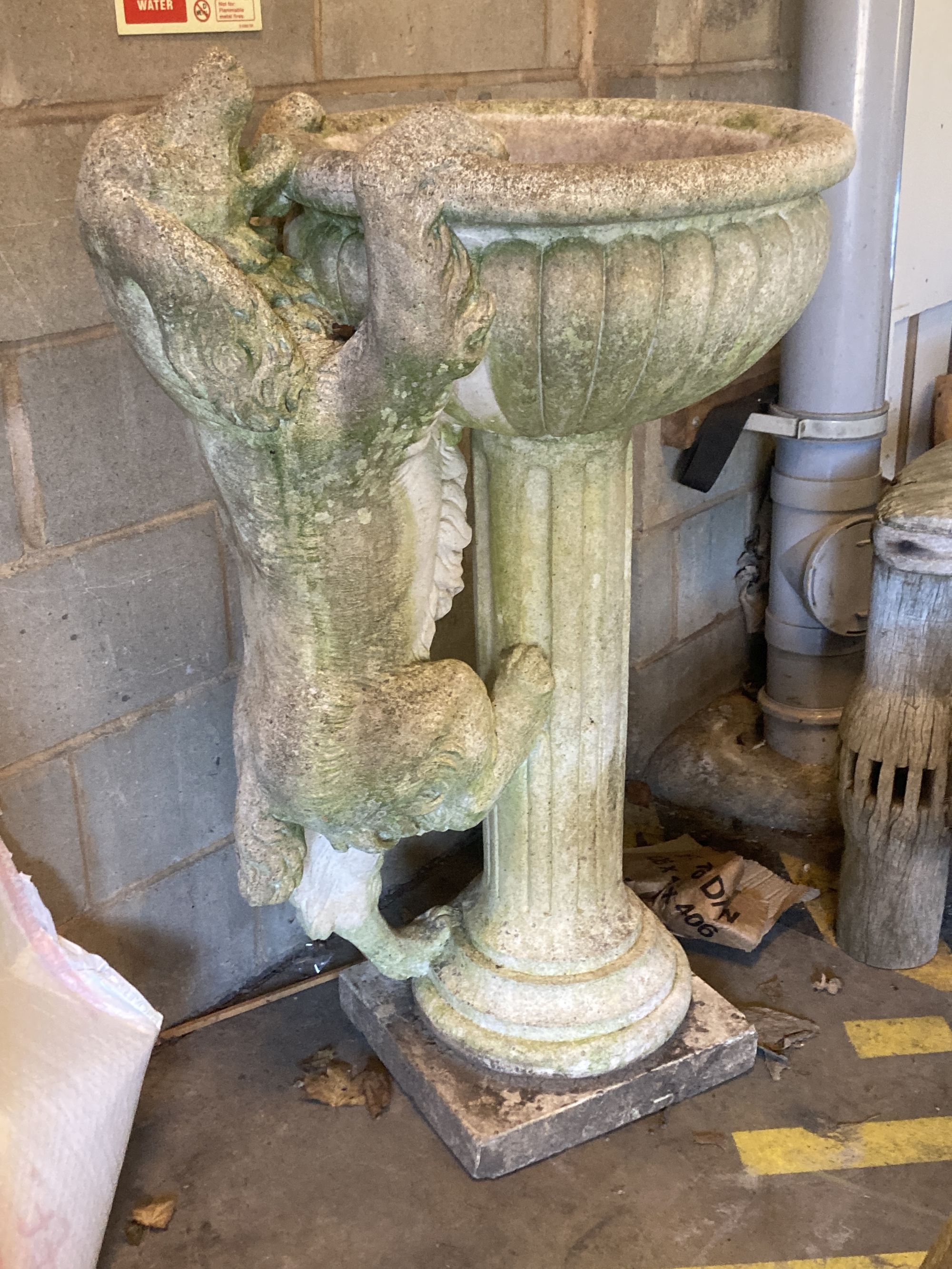 A reconstituted stone garden fountain modelled as a hound drinking from a circular bowl, width 80cm height 112cm